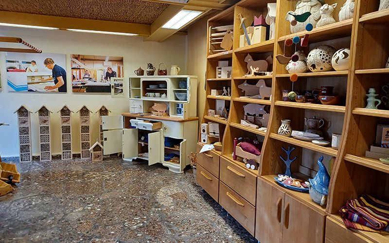 Bild zeigt verschiedene Artikel aus Holz und Keramik in Regalen im Gutshofladen.